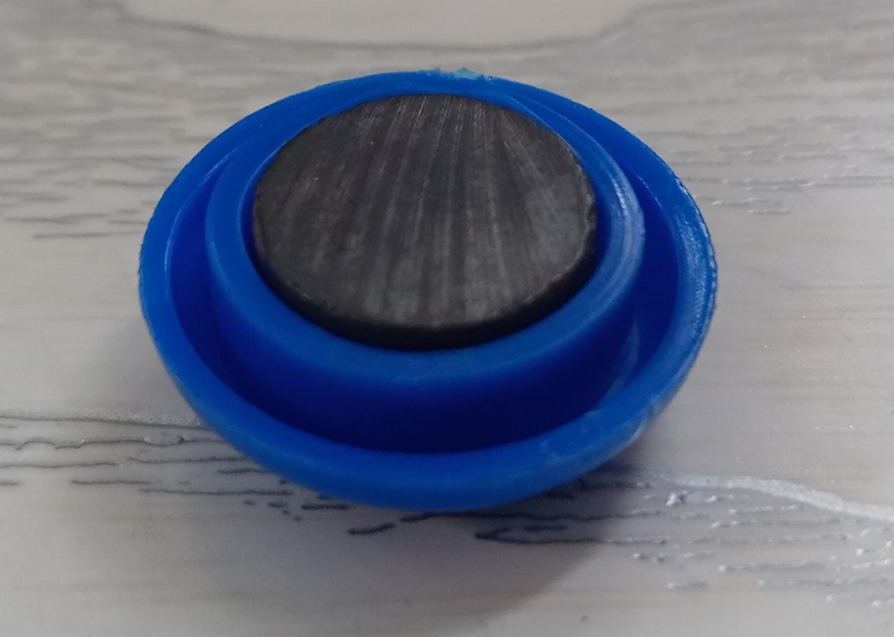 Multiple plastic magnetic buckles in various colors displayed on a whiteboard.