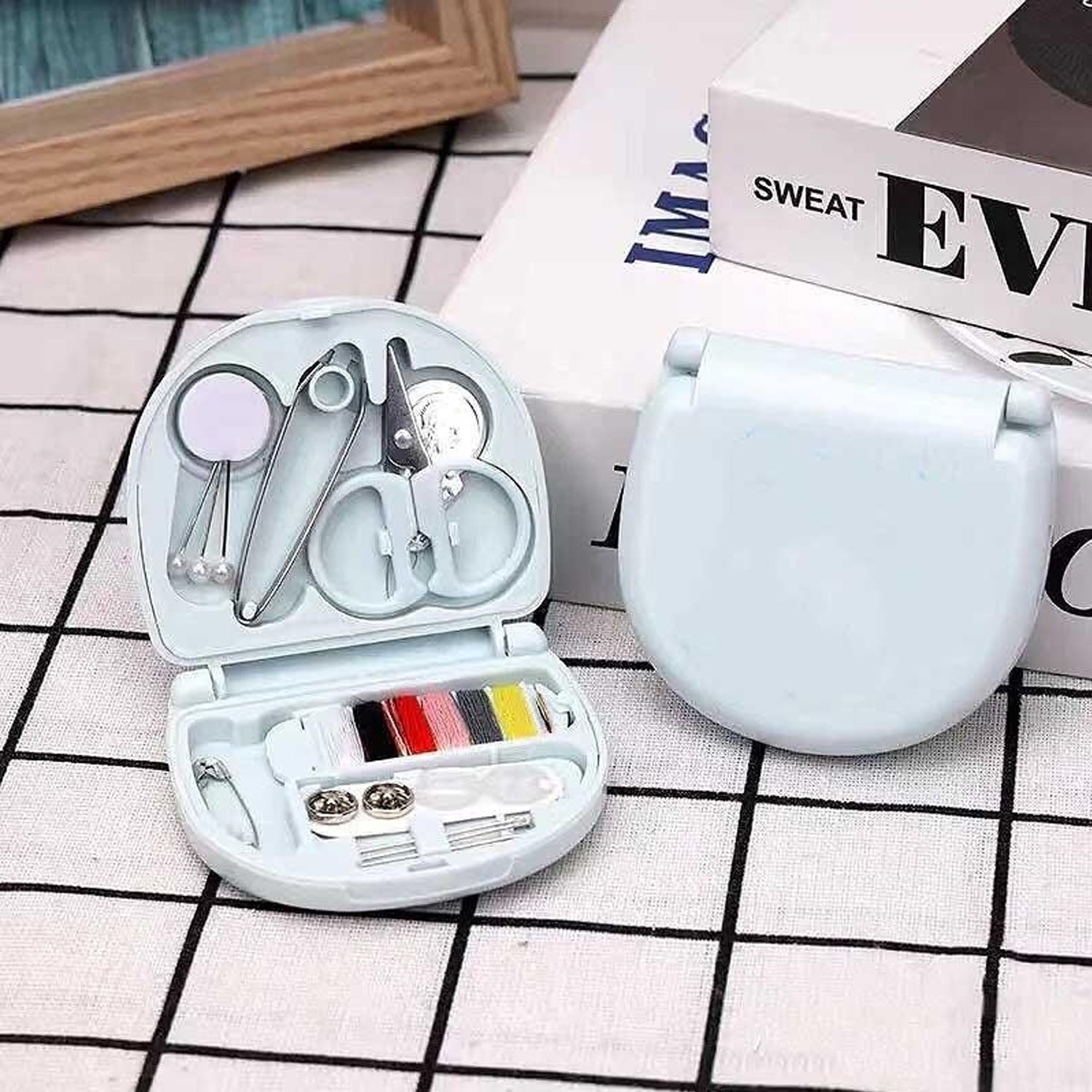 Compact Mini Travel Sewing Kit placed among other travel essentials like a passport and wallet.