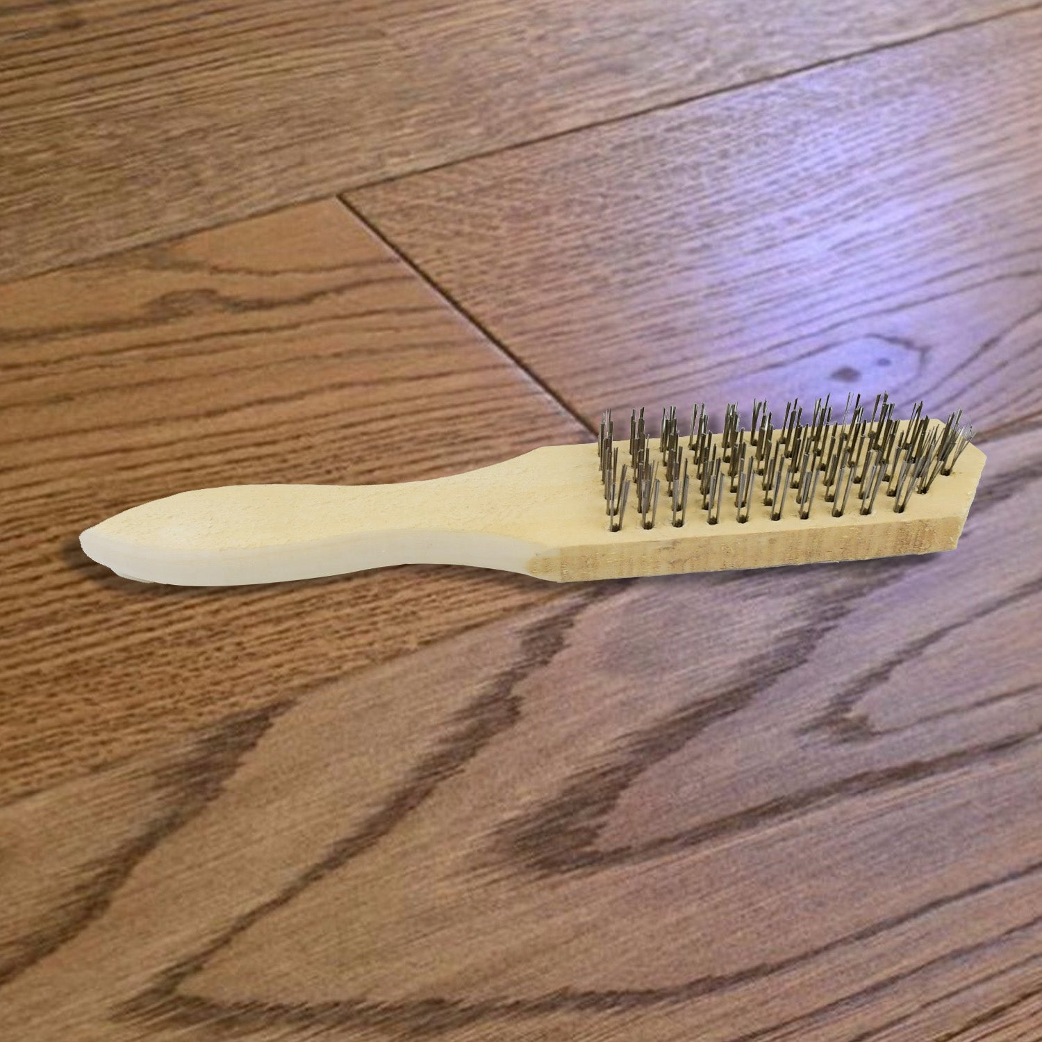 The steel wire brush on a clean white background, highlighting its design.