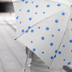 Opened dot printed umbrella showcasing its wide coverage against rain.
