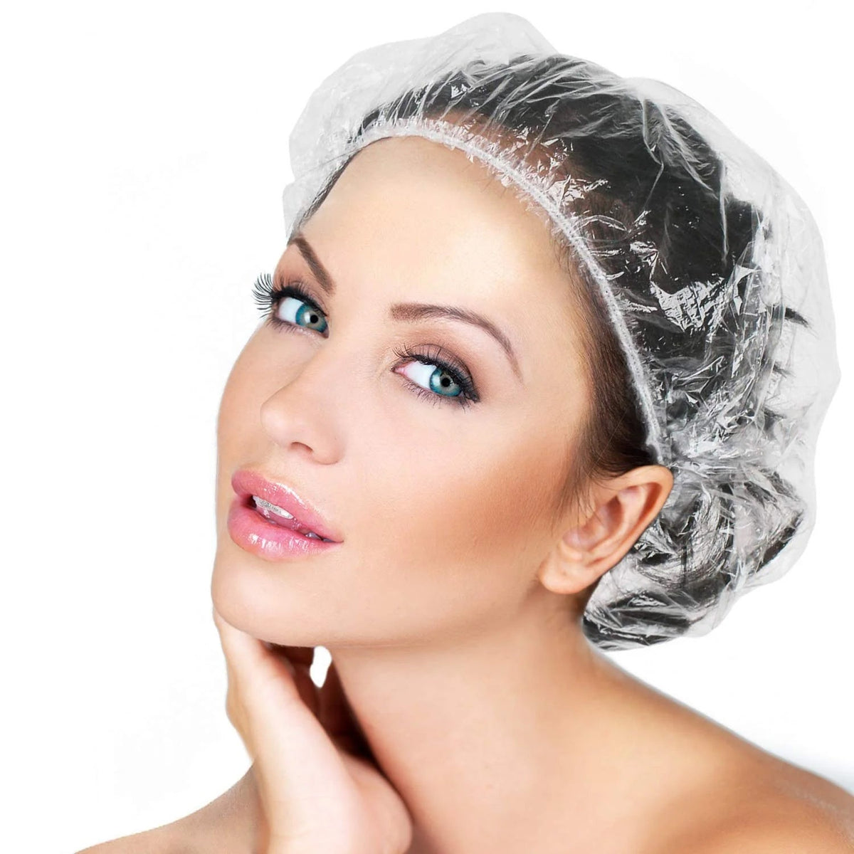 A stack of individually wrapped disposable shower caps, ready for use.