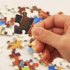 Young child happily playing with an educational cartoon jigsaw puzzle.