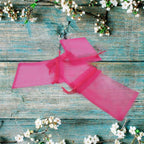 A hand holding an organza gift bag, perfect for presenting return gifts at an Indian wedding.