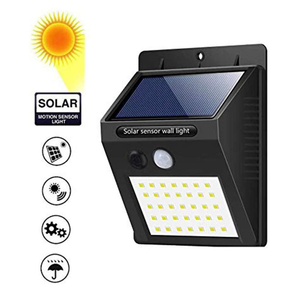 Sleek black solar LED night light illuminating a home's outdoor area.