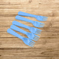 A neatly arranged set of five reusable plastic forks in a clean kitchen setting.