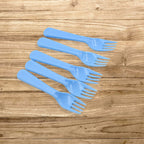 A neatly arranged set of five reusable plastic forks in a clean kitchen setting.