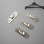 Two stainless steel self-adhesive hooks neatly holding towels in a modern bathroom.