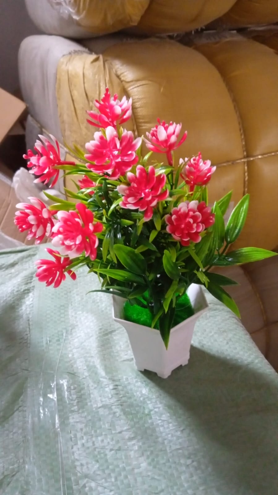 An artificial flower plant in a stylish pot, ready to enhance your home office decor.