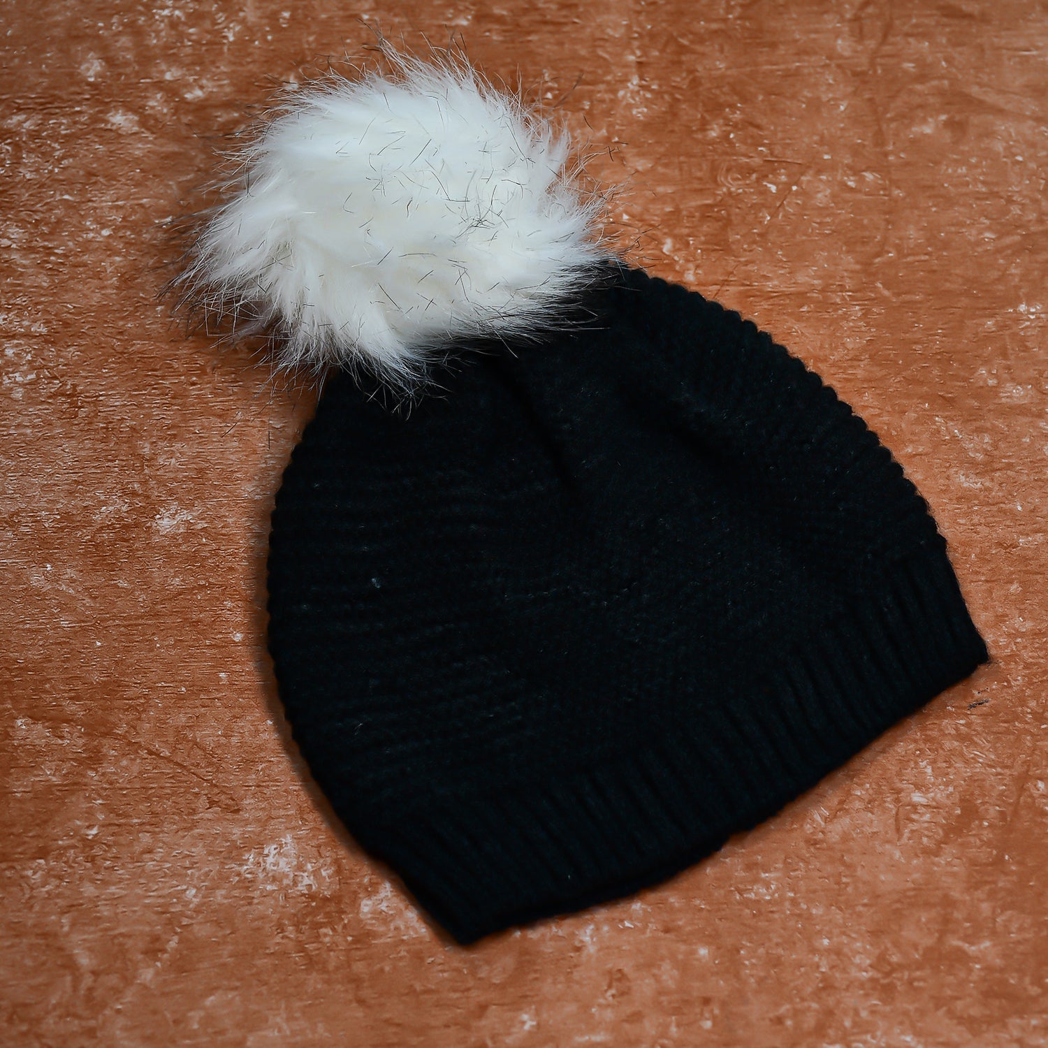 Unisex slouchy beanie cap in black with a skull design and warm fur lining.