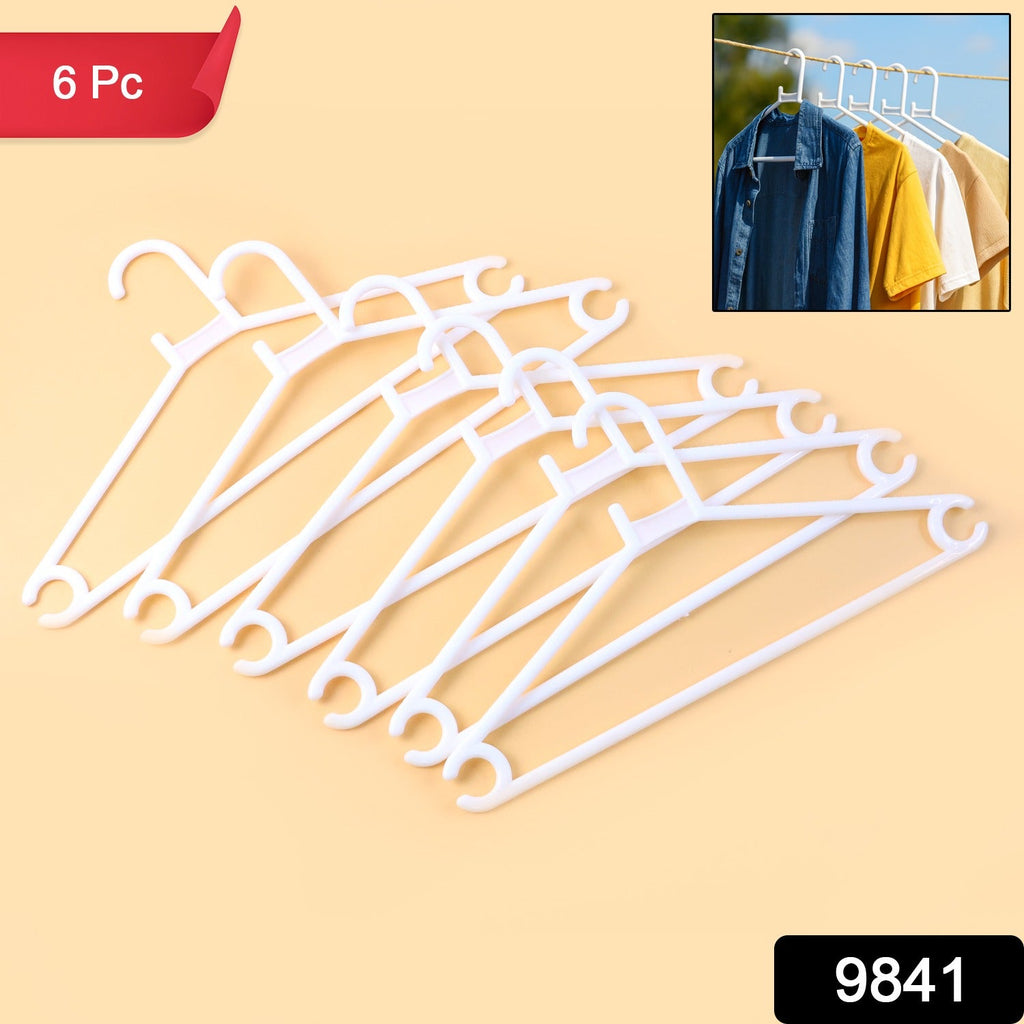 Multiple white plastic clothes hangers neatly arranged on a rack