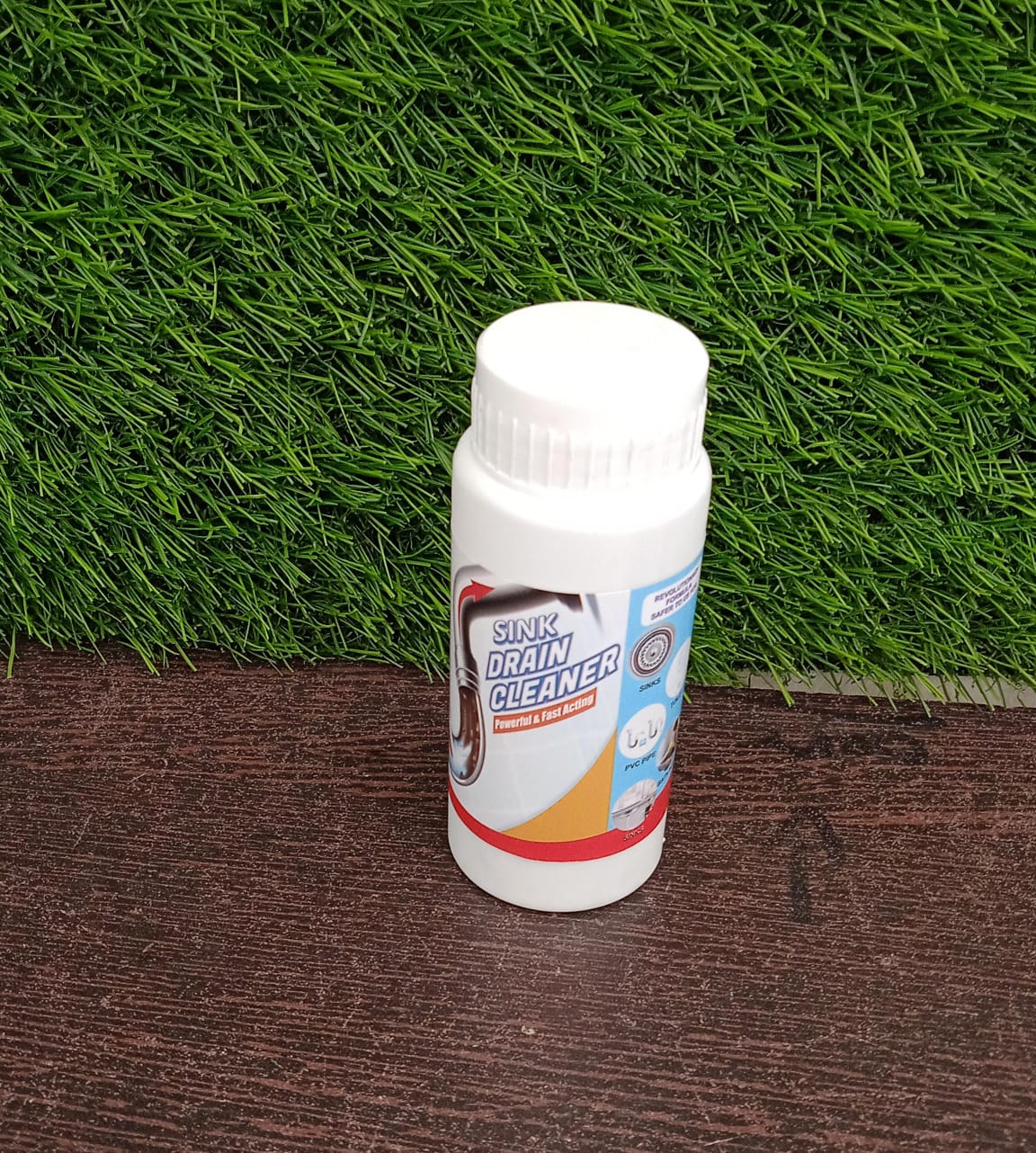 Hand holding the compact package of the powerful sink drain cleaner.