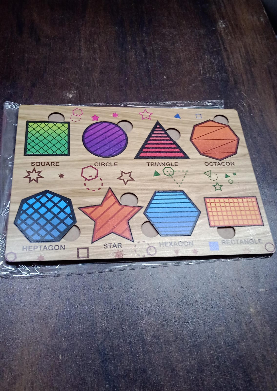 Set of wooden triangle puzzle pieces and the board, highlighting the natural wood material.