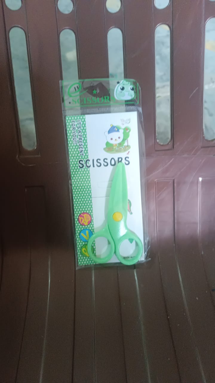 Plastic safety scissors cutting craft paper with rounded safety tips