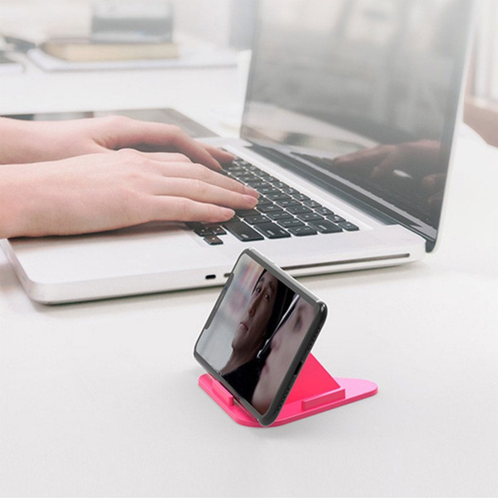 Compact pyramid phone stand in use, holding a smartphone for hands-free operation.