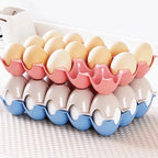 Set of four 15-cavity plastic egg trays for organised fridge storage.