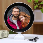 LED Magic Mirror Photo Frame glowing with a picture inside, on a white table.