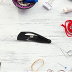 A collection of matt black hair accessories, including the Metal Tic Tac Hair Clips.