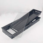 The compact charcoal cooker positioned on a picnic table, ready for grilling.