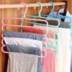 A GlimmerHome 5-layer space saving hanger neatly organising trousers in a wardrobe.