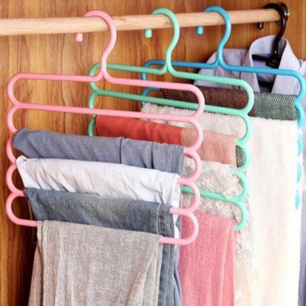 A GlimmerHome 5-layer space saving hanger neatly organising trousers in a wardrobe.