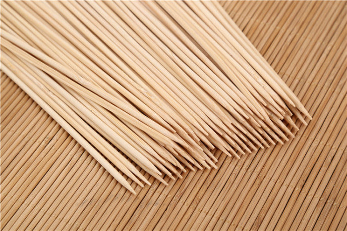Close-up of raw meat and vegetables prepared on natural bamboo skewers.