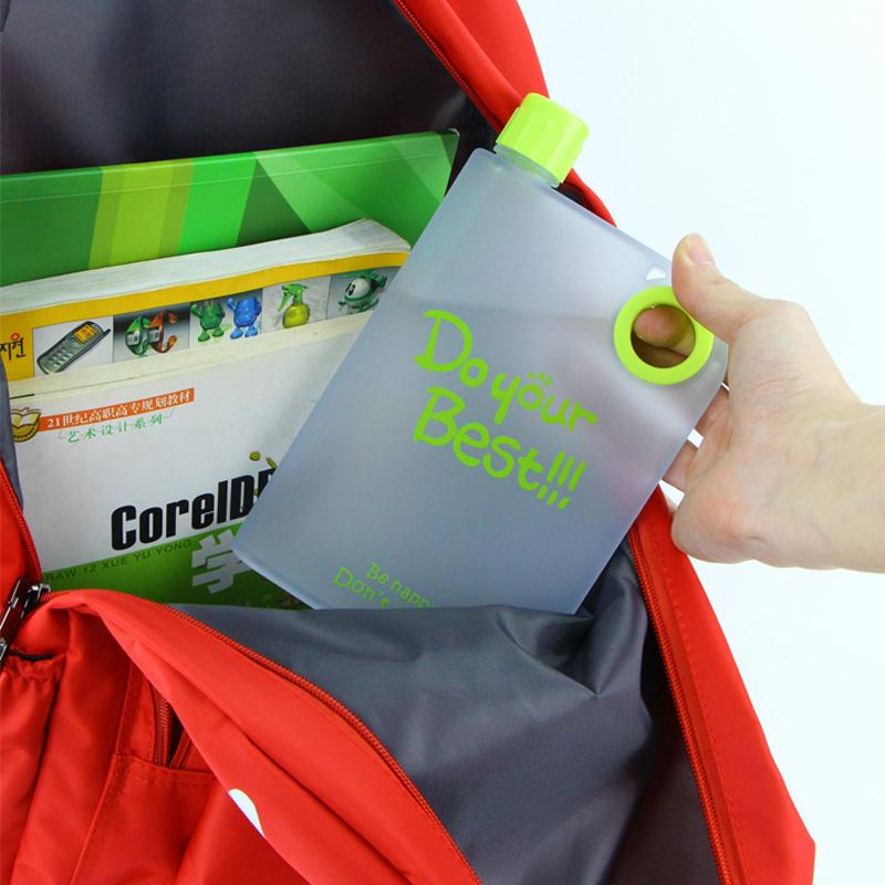 The compact notebook water bottle fitting easily into a laptop bag, demonstrating its portability.