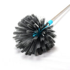 An individual using the cobweb cleaning brush to dust a high ceiling fan.