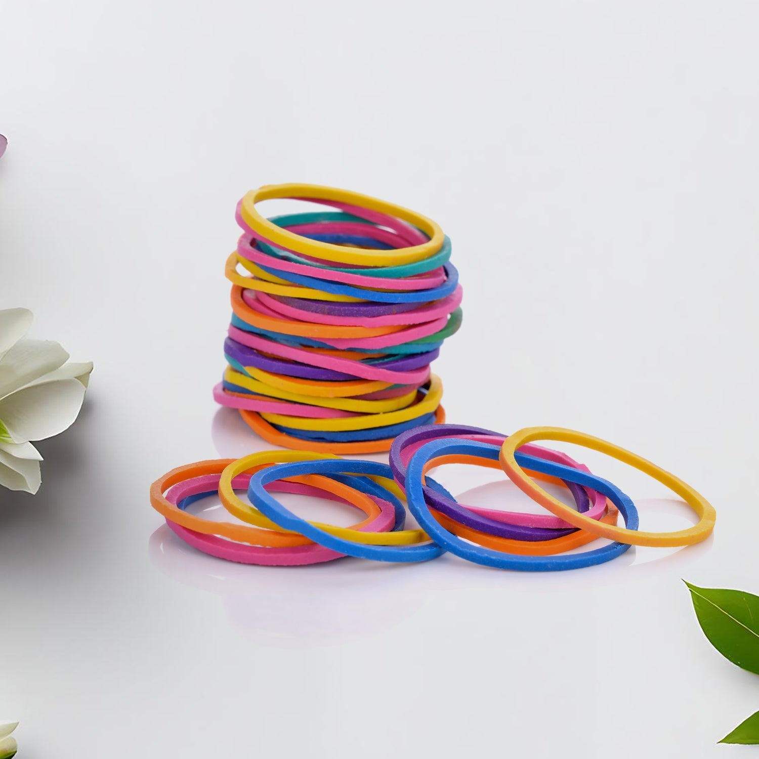 Multicolor rubber bands neatly arranged in a stack on a white surface.