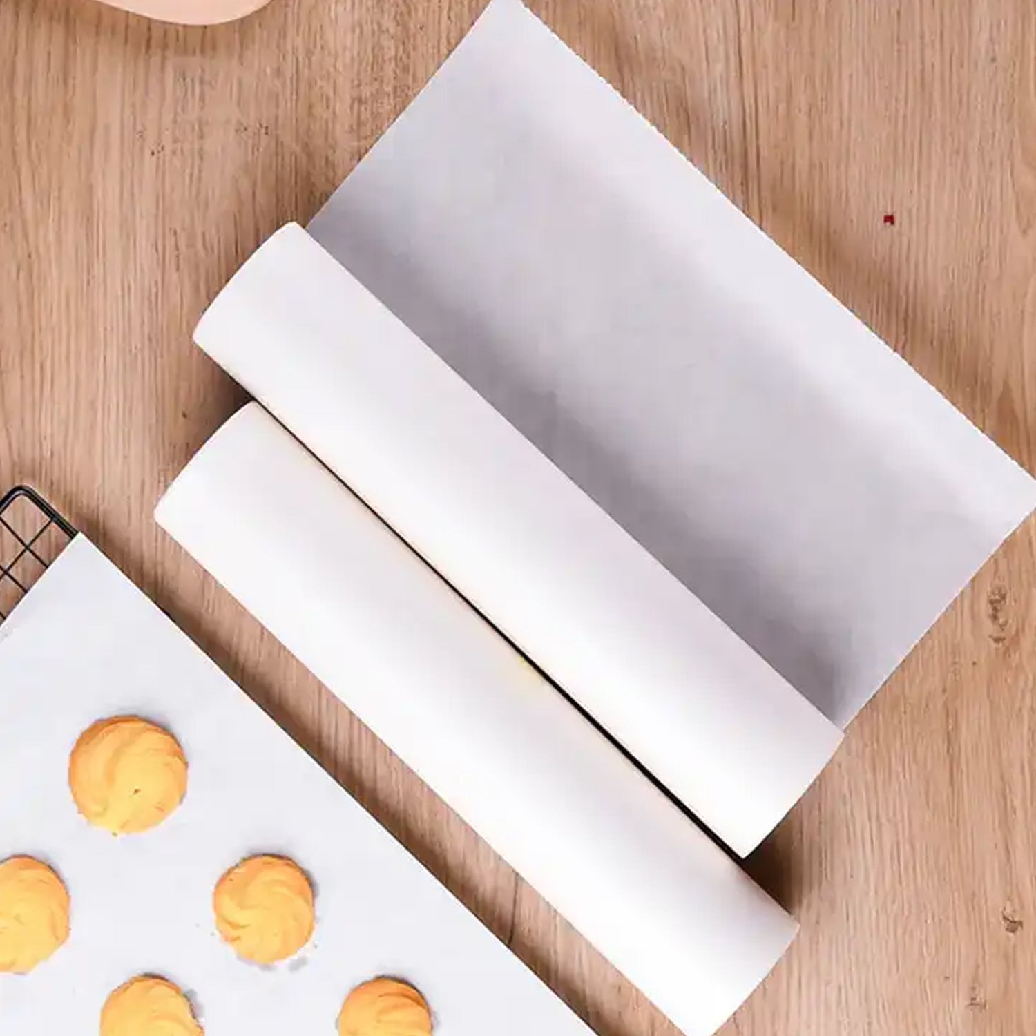 Roll of non-stick parchment paper for baking and cooking on a wooden surface.