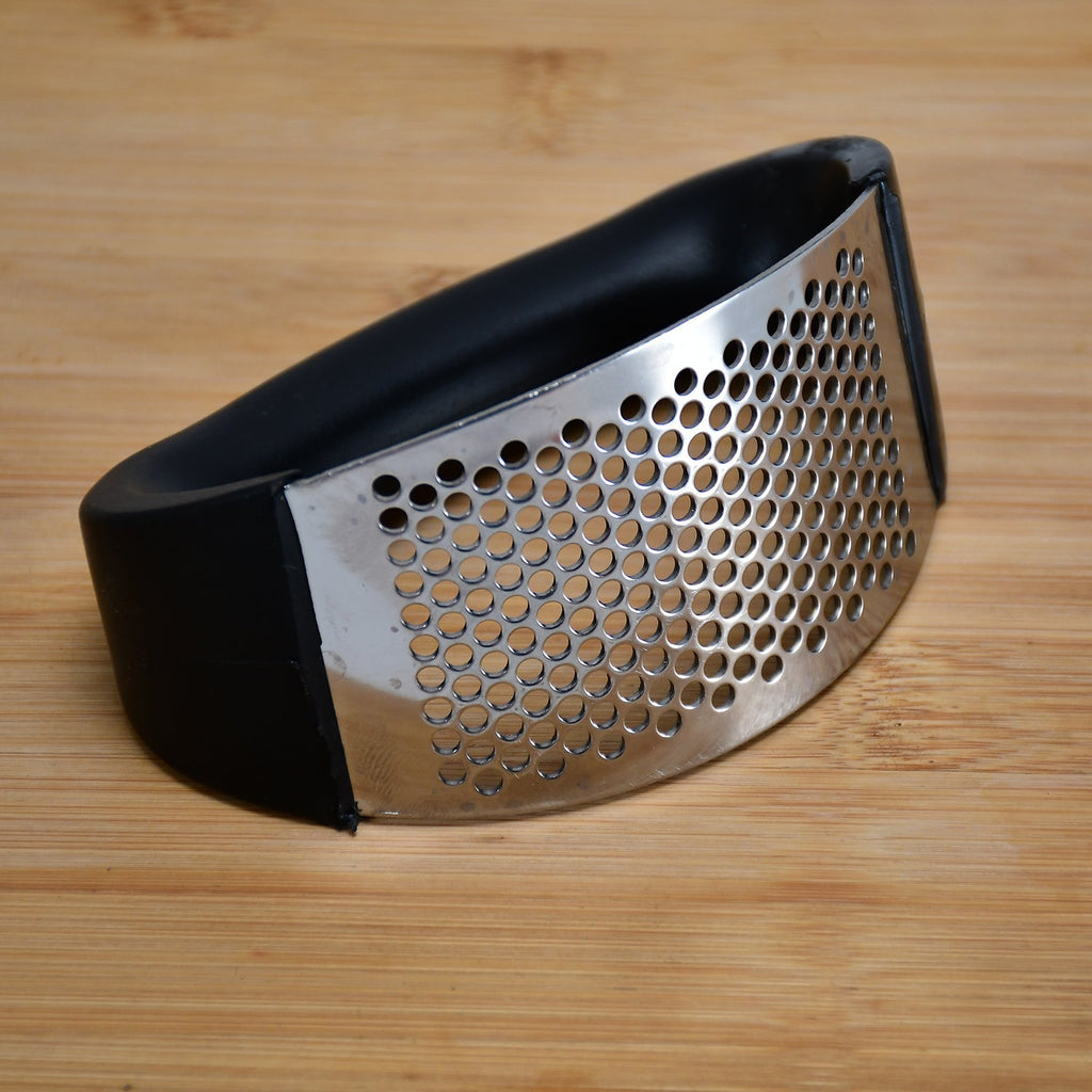 Side view of the stainless steel garlic crusher showcasing its comfortable multicolor handle design.
