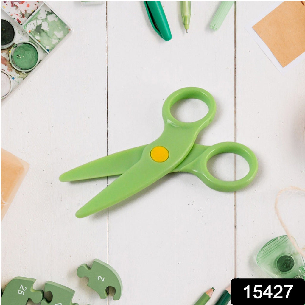 Child holding colorful plastic safety scissors practicing cutting paper