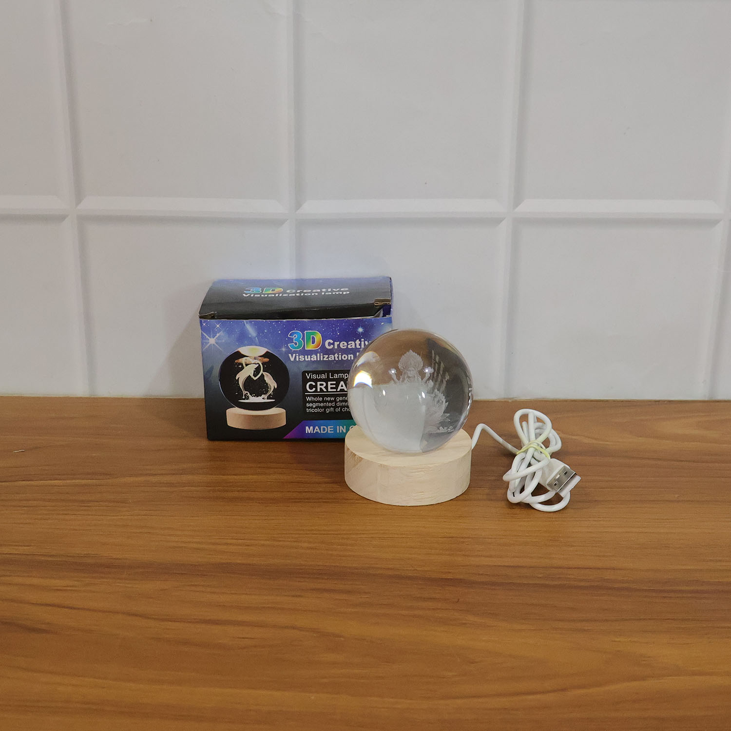 Multicolor crystal ball night light glowing on wooden base