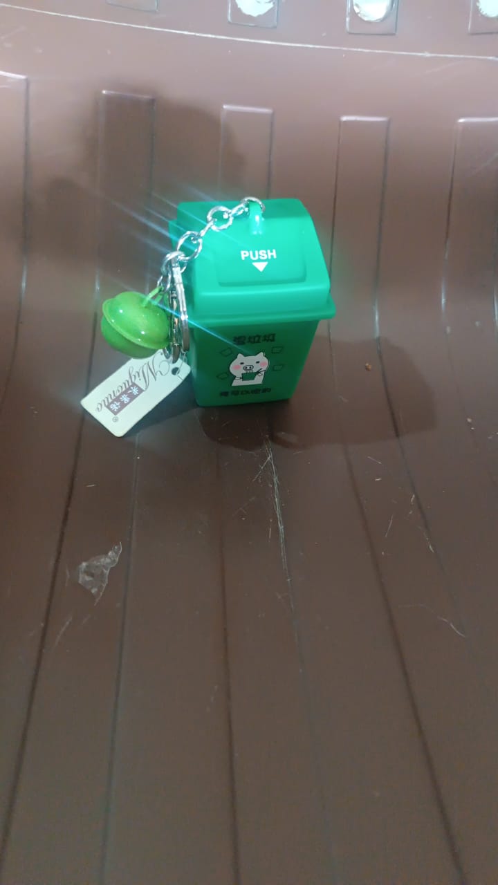 Trash Can Keychain hanging on backpack as a fun and eco-conscious accessory