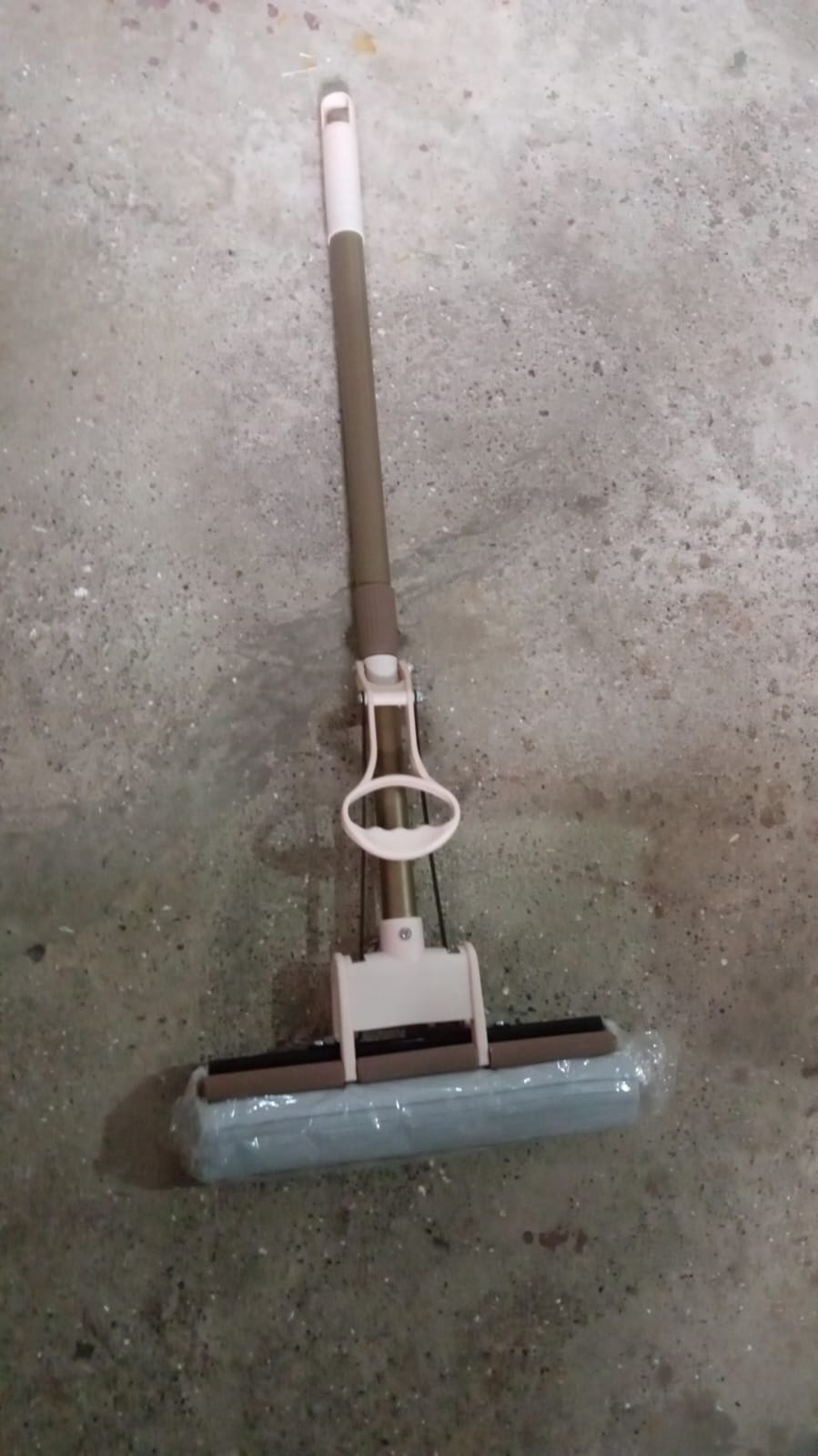 The sponge mop effectively cleaning a tiled floor, demonstrating its dirt removal capabilities.