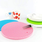 Silicone hot mat in a kitchen setting, protecting a countertop from a hot pot.