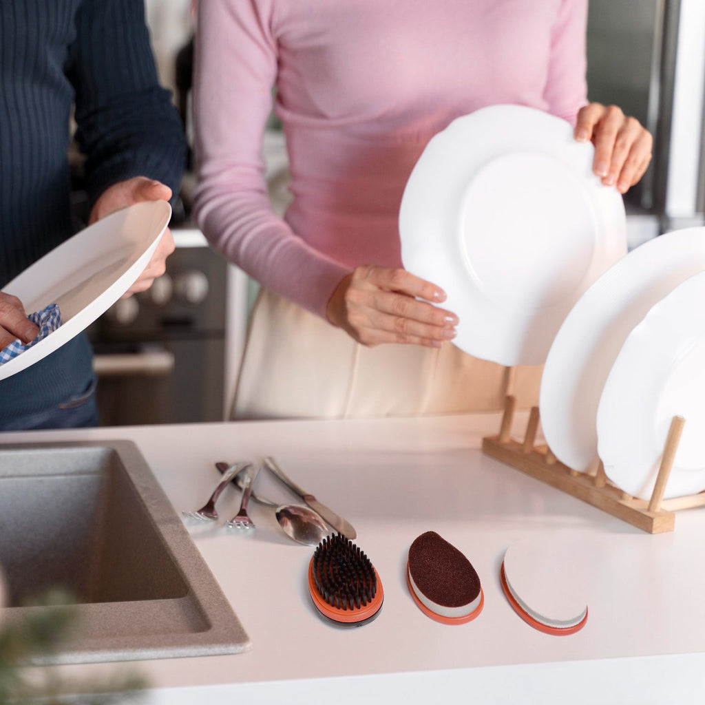 Ergonomic wet and dry brush vigorously cleaning a kitchen counter surface.