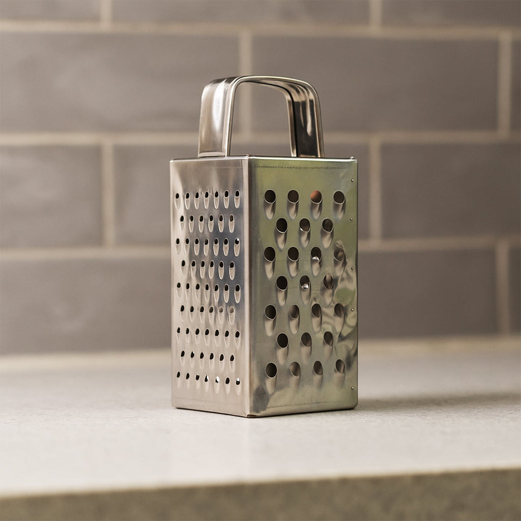 Close-up of multi-sided stainless steel grater and slicer tool