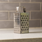 Close-up of multi-sided stainless steel grater and slicer tool