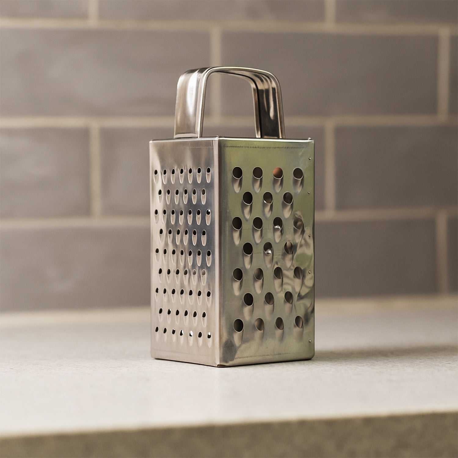 Close-up of multi-sided stainless steel grater and slicer tool