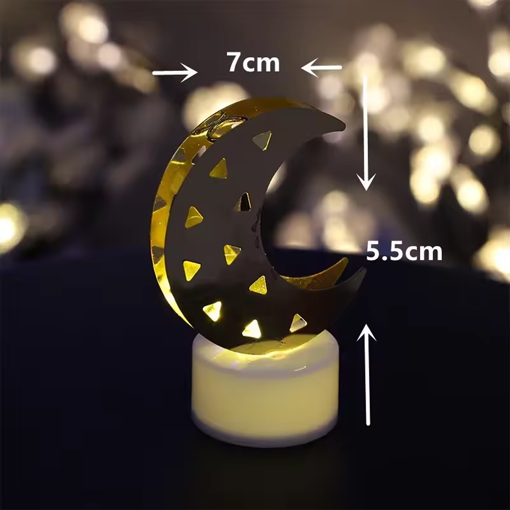 Decorative crescent moon shaped flameless LED candle emitting warm yellow glow