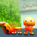 Close-up of a smiling emoticon shaking head doll with a spring neck, perfect for car dashboards.