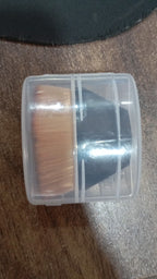 BeautyBare foundation brush neatly stored inside its round, portable protective case.