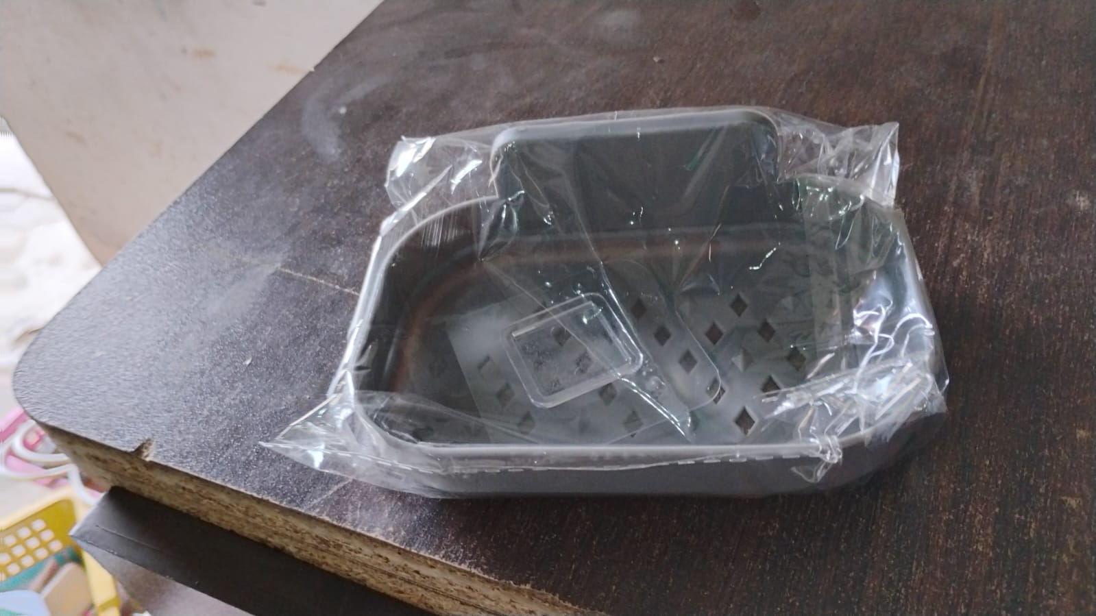 Compact soap dish holder neatly mounted in a shower area, saving space.