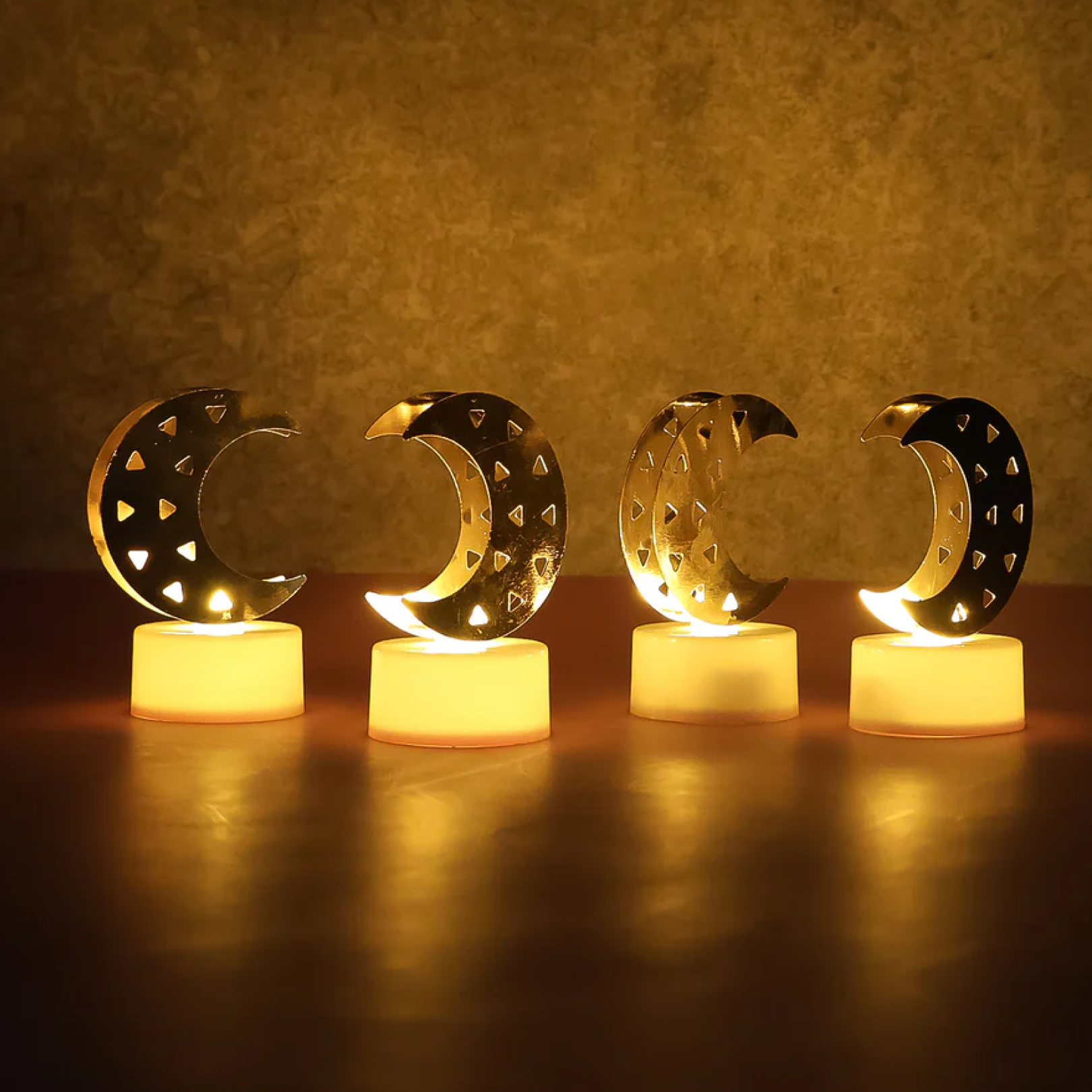 Twelve decorative moon shaped LED candles arranged for ambient home and event decor