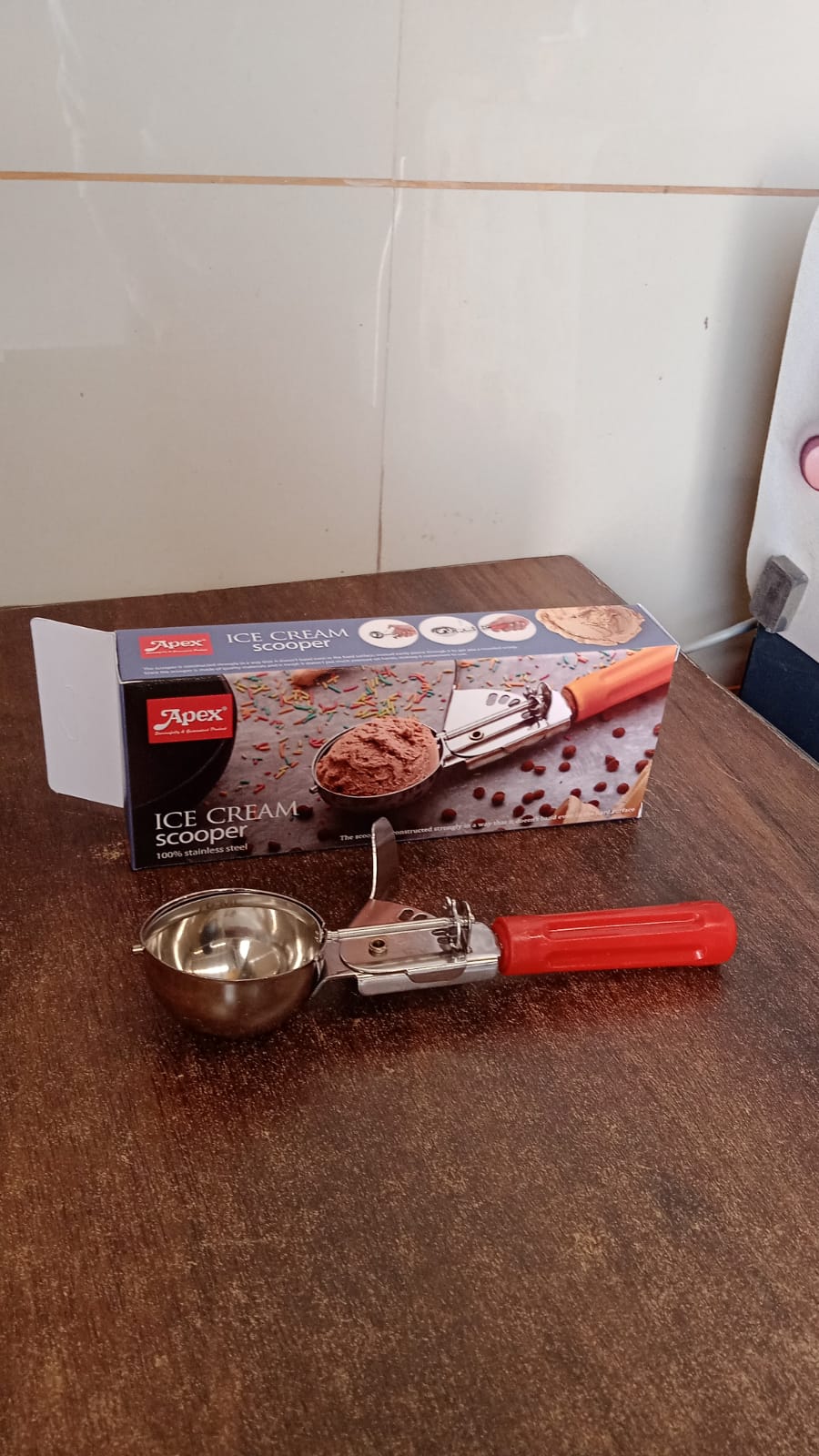 Angled view of Apex ice cream scoop with stainless steel head and handle