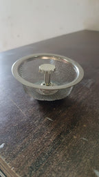 Angled view of the polished stainless steel kitchen sink strainer.