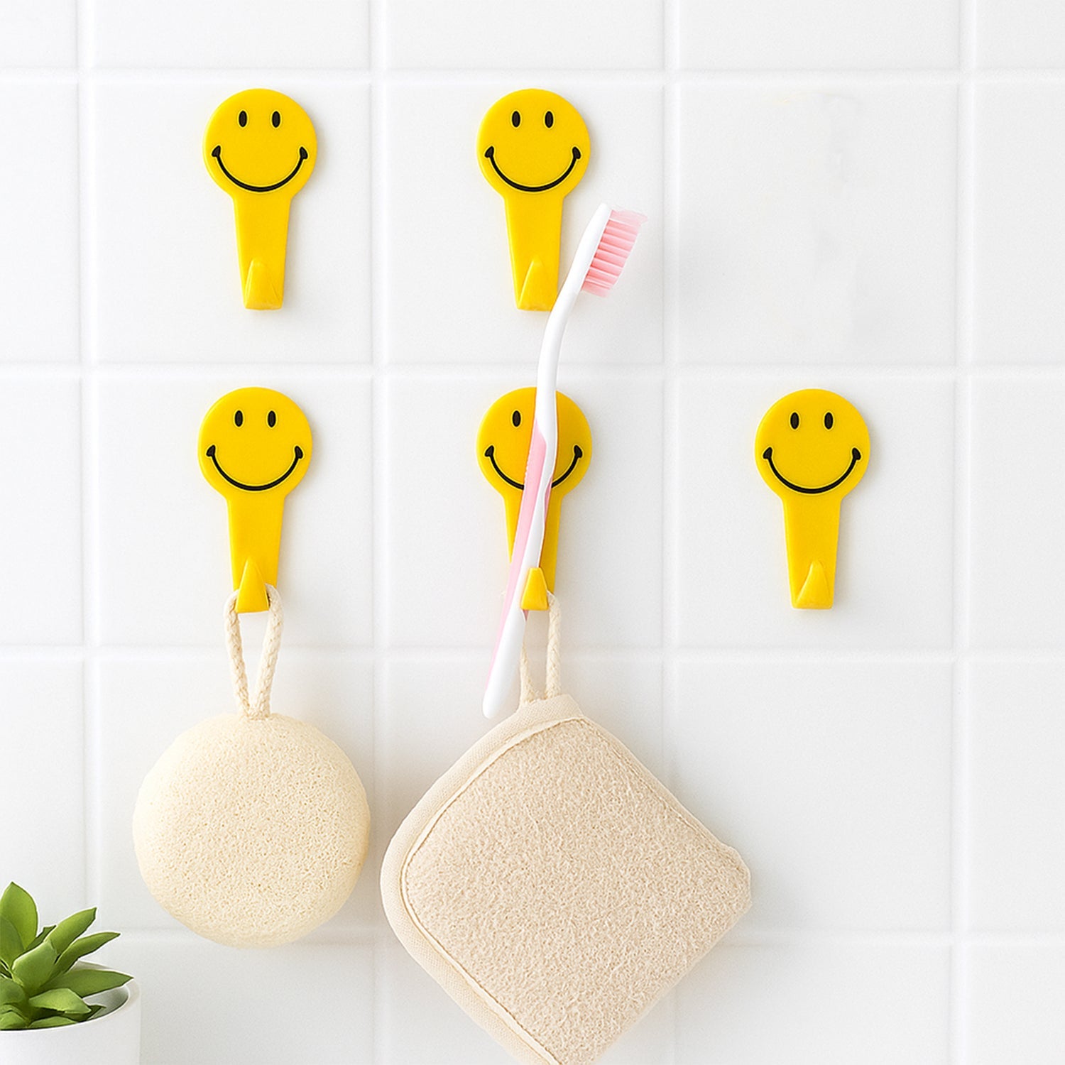 Waterproof self adhesive hooks holding towels in a modern bathroom.