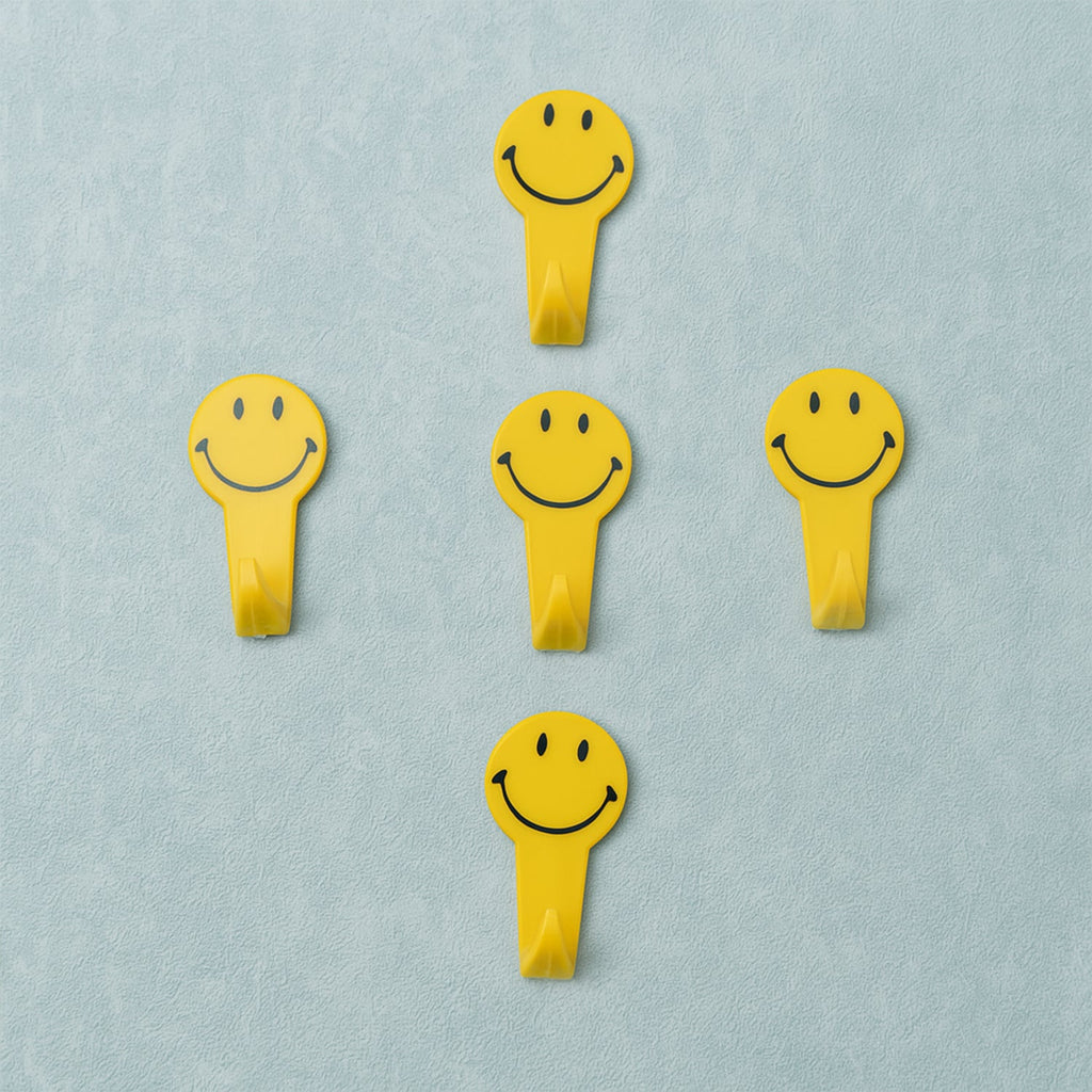 A set of five white self adhesive hooks displayed on a clean surface.