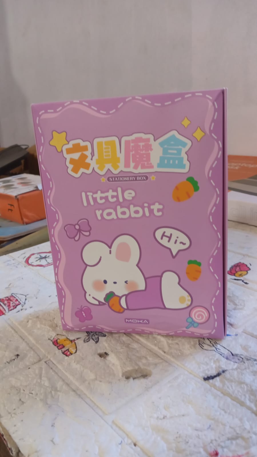 Top view of a cartoon school box, showcasing multiple stationery items and a pen refill.