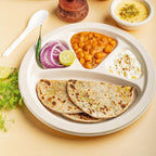Disposable 4 compartment meal serving plate holding snacks and main course